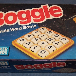 May include: A vintage Boggle word game box with the game title in large red letters. The box features a blue background, a yellow grid of lettered dice, and a yellow hourglass. The Parker Brothers logo is visible.