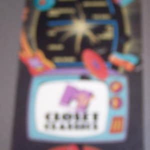 May include: A colorful VHS tape featuring a retro design. The tape has a black background with a television, a red disc, and the text "CLOSET STATION!" in white. The design includes blue, purple, orange, and red elements.