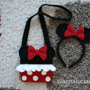 Pu&ograve; includere: Un set di borsa e fascia per capelli Minnie Mouse in crochet nero e rosso. La borsa ha un bordo a balze bianche e pois rossi. La fascia ha orecchie nere con fiocchi rossi.