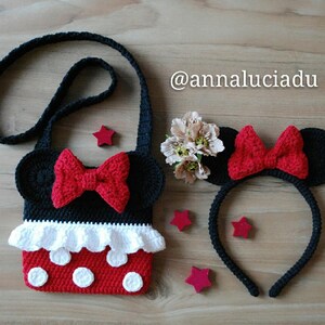 Pu&ograve; includere: Una borsa a tracolla in crochet nero a tema Minnie Mouse con un fiocco rosso e pois bianchi. La borsa ha una tracolla nera ed &egrave; abbinata a una fascia per capelli in crochet nero con fiocco rosso e orecchie nere.