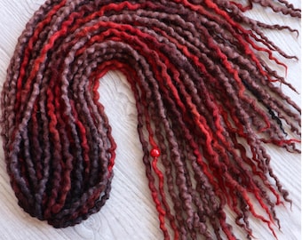 May include: A set of long, red and brown wool dreadlocks. The dreadlocks are arranged in a loose, flowing style.