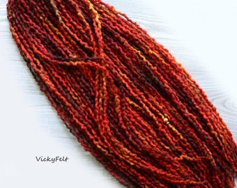 May include: A set of long, red, orange, and brown wool dreadlocks with a gold bead accent. The dreadlocks are made of wool yarn and are perfect for adding a touch of color and texture to your hair.