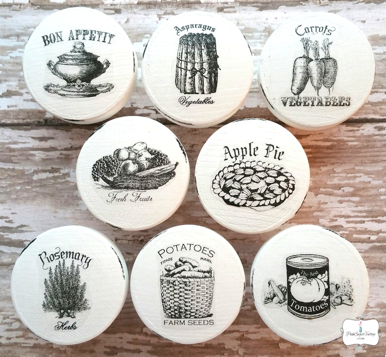 Peut inclure: Ensemble de 8 couvercles ronds en bois blanc pour bocaux avec des illustrations et du texte vintage en noir et blanc. Les couvercles pr&eacute;sentent des images d'asperges, de carottes, de fruits frais, de tarte aux pommes, de romarin, de pommes de terre, de tomates et d'un plat de service. Le texte sur les couvercles comprend "Bon Appetit", "Asparagus Vegetables", "Carrots Vegetables", "Fresh Fruits", "Apple Pie", "Rosemary Herbs", "Potatoes Trade Mark Farm Seeds", et "Tomatoes".