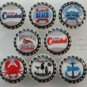 Pode incluir: Uma coleção de ímanes de tampas de garrafa com designs costeiros e de praia. Os ímanes apresentam imagens de caranguejos, âncoras e textos como "Going Coastal", "Beach" e "Margarita Cocktails". A paleta de cores inclui azul, vermelho e branco.