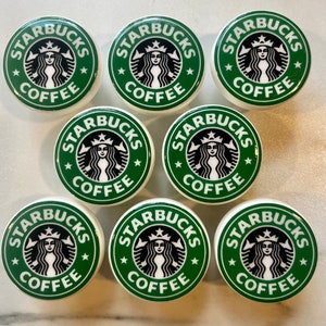 Könnte beinhalten: Neun runde, grün-weiße Keramikknöpfe mit dem Starbucks-Logo und dem Schriftzug "Starbucks Coffee".