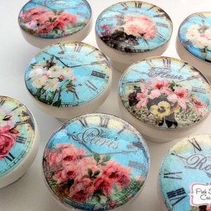 Puede incluir: Conjunto de diez pomos de cerámica con un diseño floral vintage. Cada pomo presenta un fondo azul con una esfera de reloj y detalles florales. Los pomos son perfectos para añadir un toque de encanto vintage a cualquier hogar.