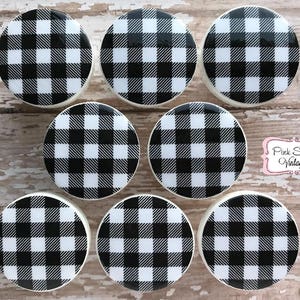 Puede incluir: Ocho pomos redondos de cerámica con estampado de cuadros negros y blancos.