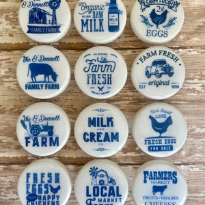 Puede incluir: Diez tapas de tarro de cerámica blanca con diseños azules y blancos. Los diseños incluyen huevos frescos de la granja, leche y crema, granja local, productos frescos de la granja y mercado de agricultores.