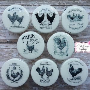 Puede incluir: Conjunto de 8 tapas de tarro de cerámica blanca con ilustraciones de gallos y gallinas en blanco y negro. Las tapas presentan varios diseños, incluyendo "Farm Fresh Eggs", "Moulins de Provence" y "Organic Chicken Feed".