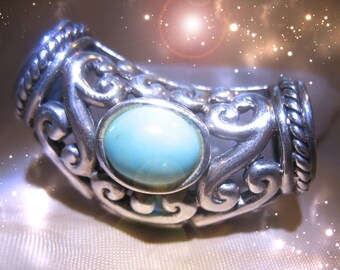 May include: A silver ring with a turquoise stone set in a decorative filigree design.