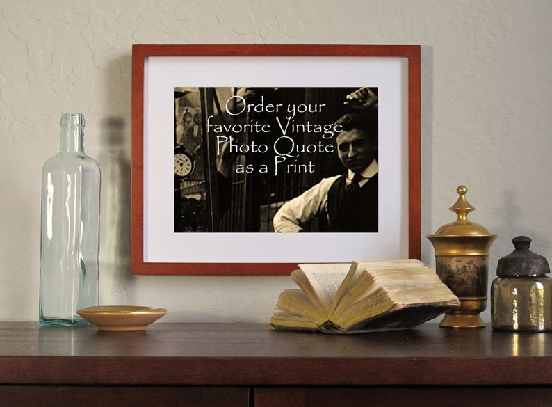 Puede incluir: Una impresi&oacute;n enmarcada con el texto "Order your favorite Vintage Photo Quote as a Print". La impresi&oacute;n est&aacute; en un marco marr&oacute;n y presenta una imagen sepia de un hombre. Otros elementos en la mesa incluyen una botella de vidrio, un plato peque&ntilde;o y un libro abierto.