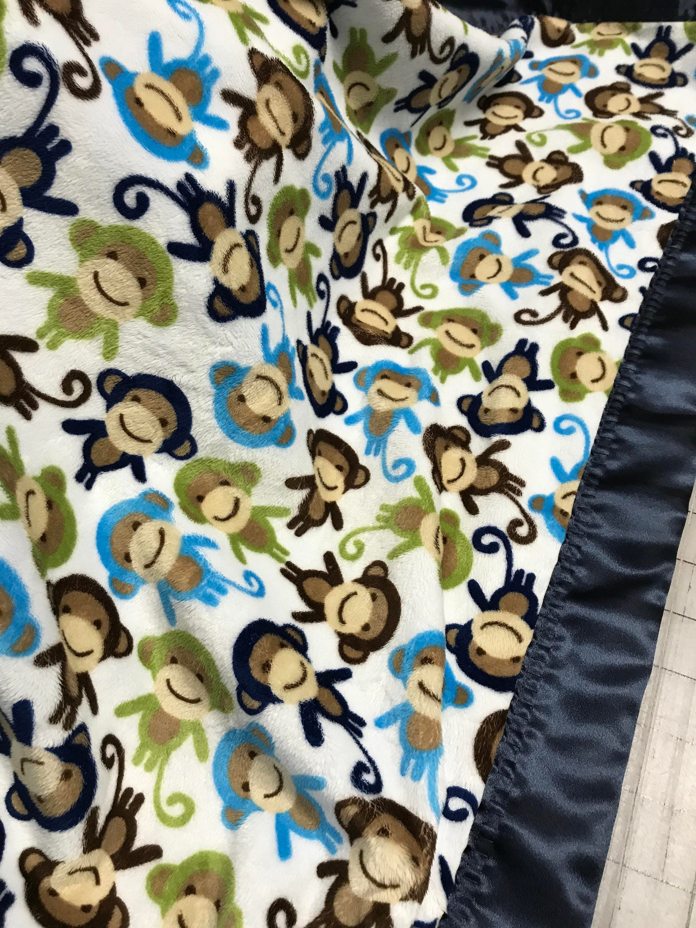 Monkeys all around minky baby blanket with navy satin backing and binding