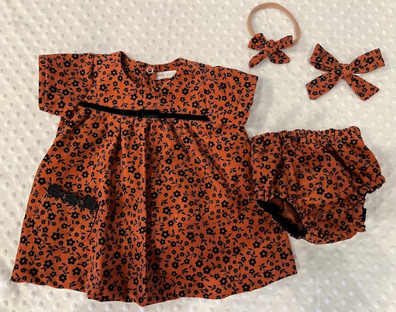 Rust with black flowers short sleeve dress with bloomers and matching bow.