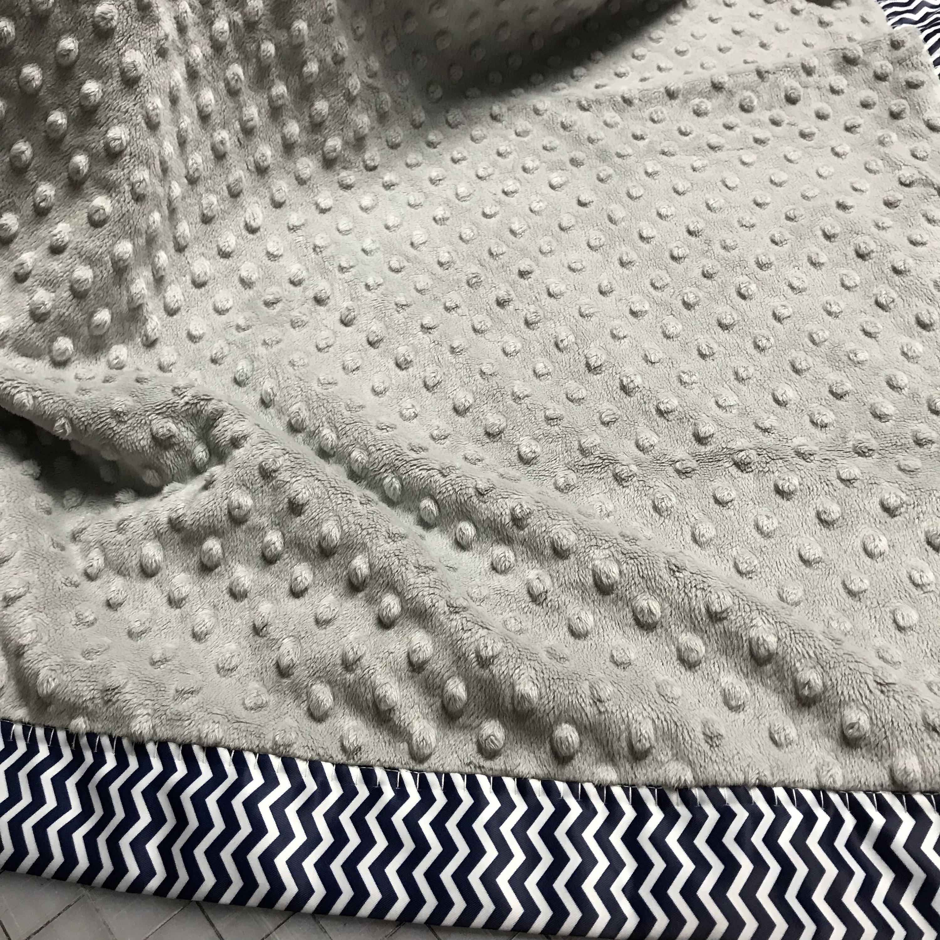 Gray minky dot baby blanket with navy and white chevron binding and
