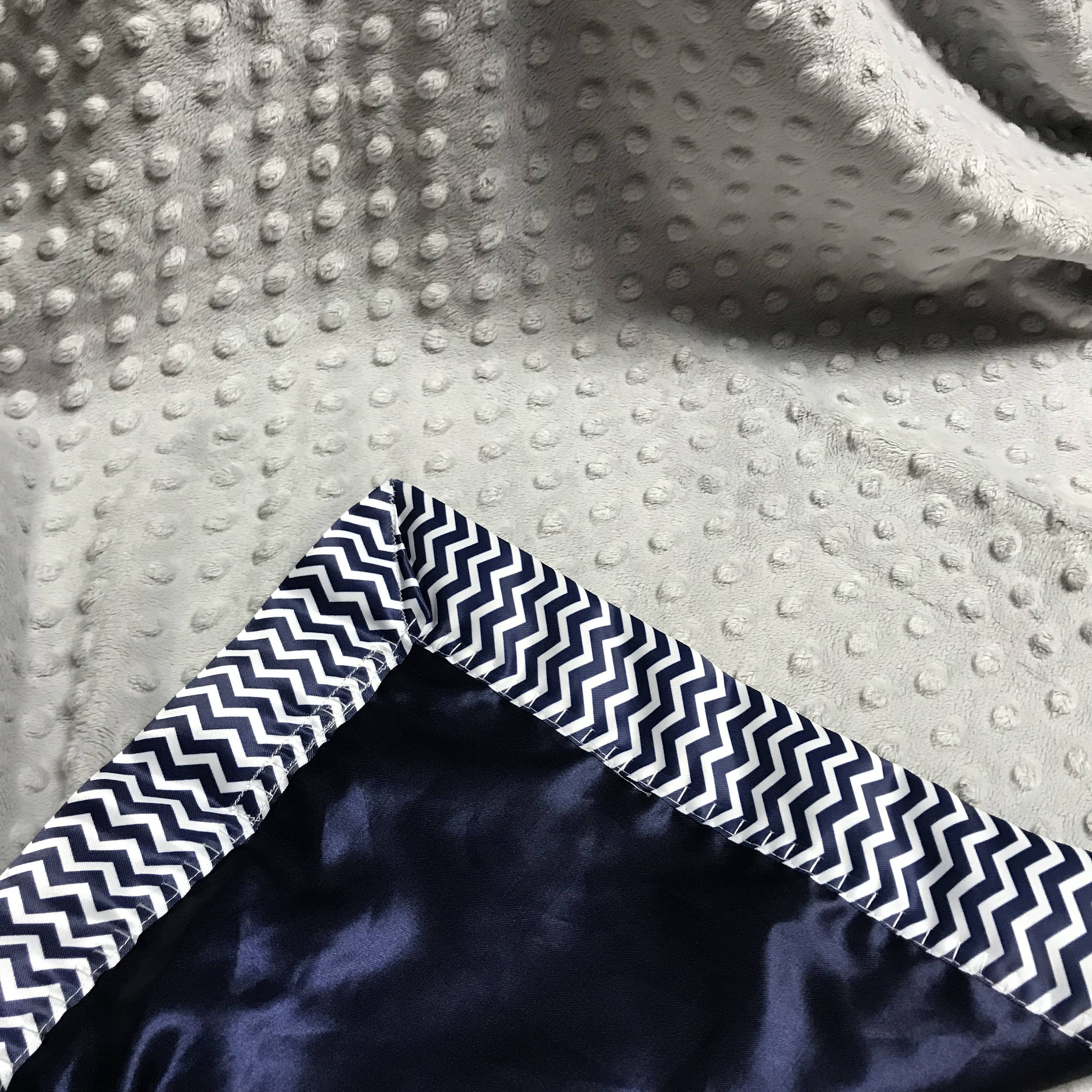 Gray minky dot baby blanket with navy and white chevron binding and