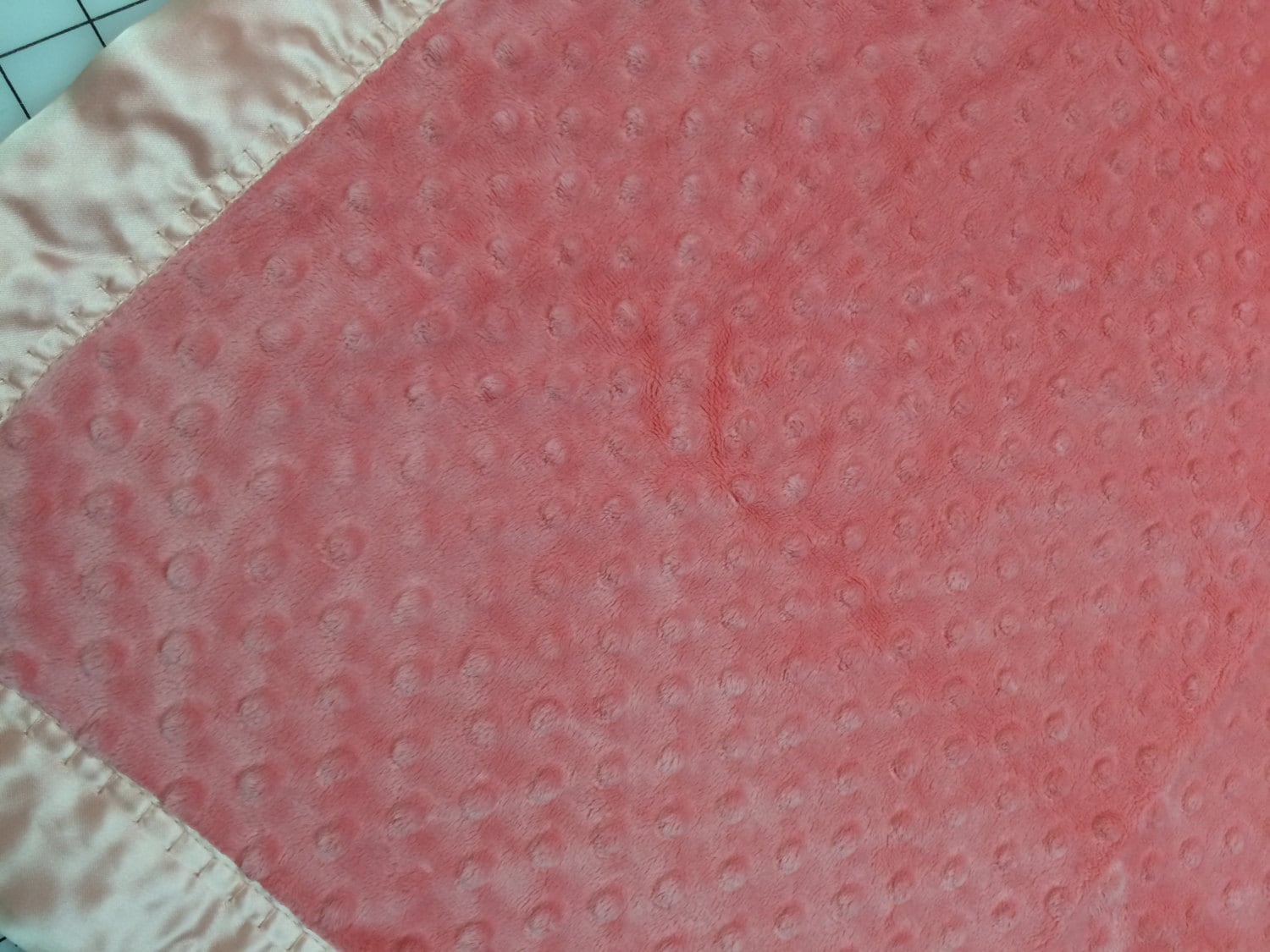 30 x 35 Coral minky dot baby blanket with white satin backing and