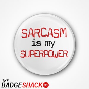 May include: White button with red text that reads "Sarcasm is my superpower".