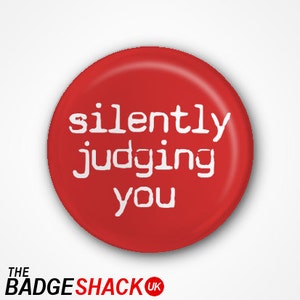 Puede incluir: Botón redondo rojo con texto blanco que dice "silently judging you".