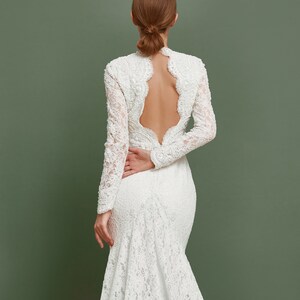 Open back of this mermaid gown is heavy embroidered with pearls an sequins.