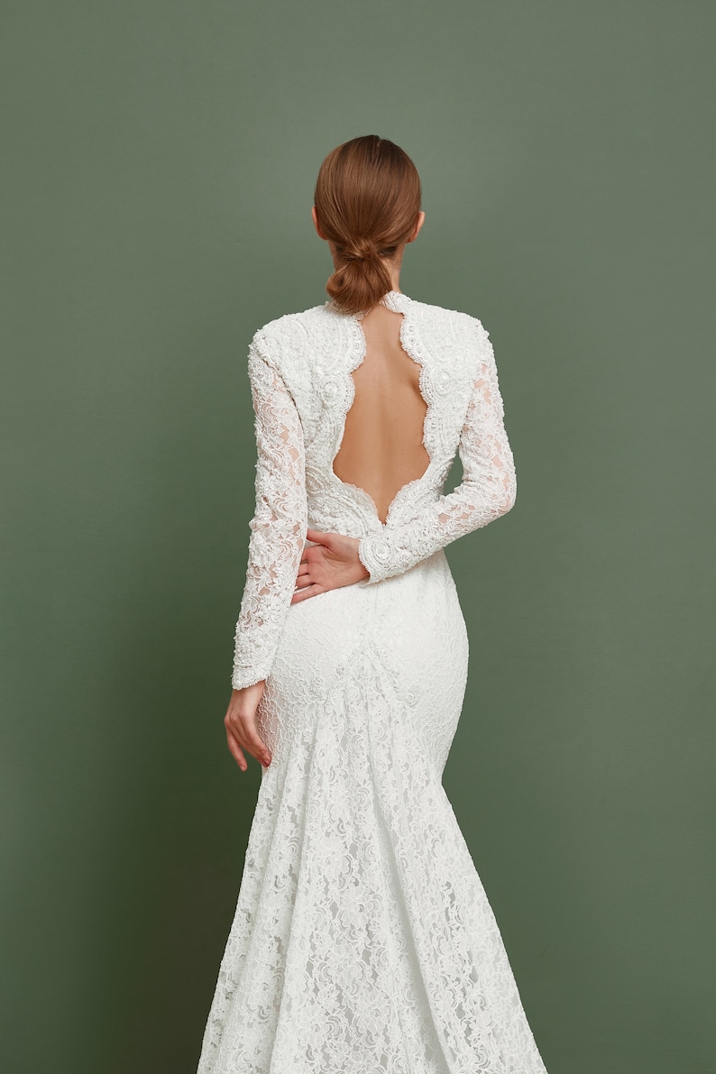 Open back of this mermaid gown is heavy embroidered with pearls an sequins.