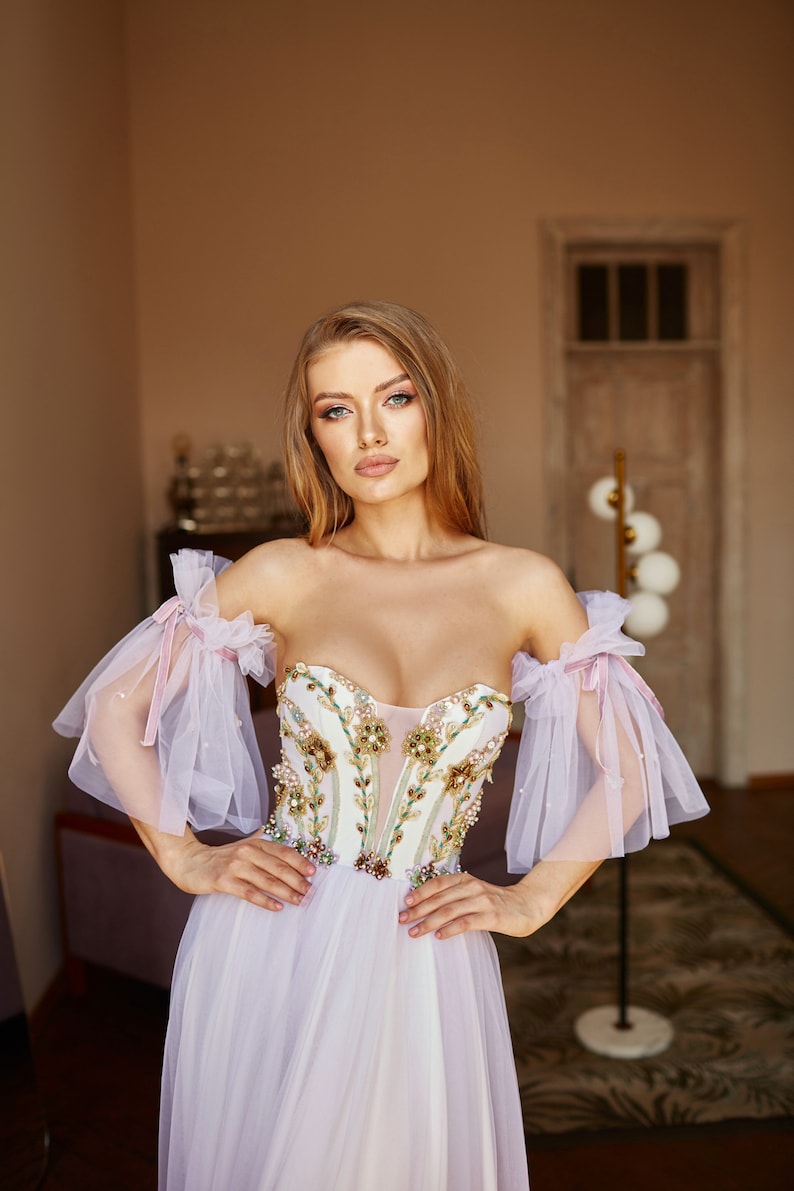 bohemian wedding dress with detachable sleeves and V-shape corset.
Purple Ombre Color. Fit and flare skirt.
Floral embroidery on bodice.
Perfect choice for boho wedding dress, alternative bride or prom dress.