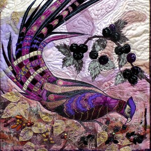 May include: A purple and gold pheasant with a long tail, perched on a branch with black berries. The background is a soft purple and white quilted fabric.