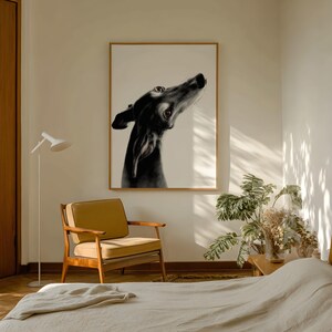 This evocative artwork, 'Always There,' beautifully illustrates the transition of a rescue dog into a devoted companion. Through delicate brushwork and a focus on black Greyhound Trijn’s watchful eyes, the artist portrays the quiet vulnerability and emerging trust of a Spanish Greyhound who has finally found her 'forever' person. Framed in a wooden frame, displayed in a minimalist bed room.
