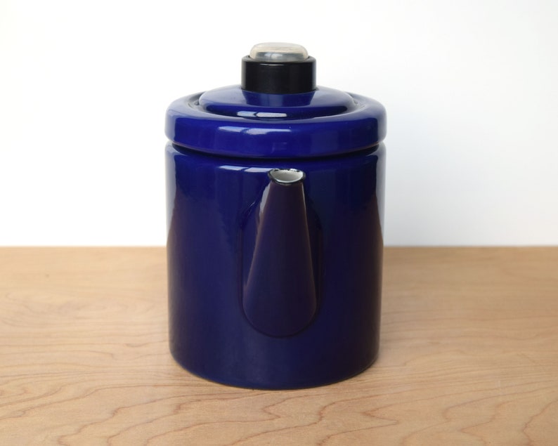 K&ouml;nnte beinhalten: Eine blaue Emaille-Kaffeekanne mit schwarzem Deckel und silbernem Ausguss.