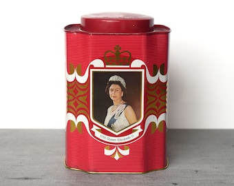 May include: Red metal tin with a gold and white design featuring a portrait of Queen Elizabeth II. The tin has the text "H.M. Queen Elizabeth II" and "1952 - 1977".