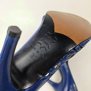 May include: Blue leather high-heeled shoes with a cut-out design on the top. The shoes are made in Italy and the size is 35.