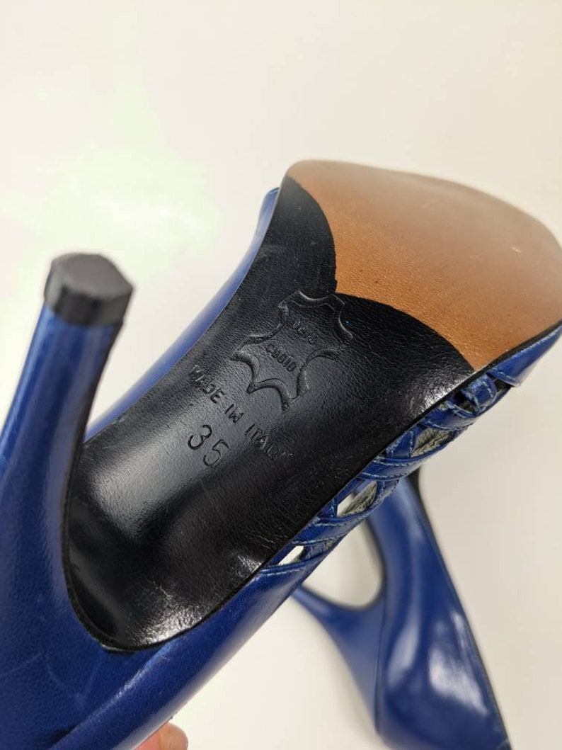 May include: Blue leather high-heeled shoes with a cut-out design on the top. The shoes are made in Italy and the size is 35.