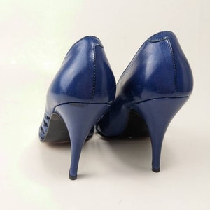 May include: A pair of blue leather high-heeled shoes with a cut-out design on the sides.