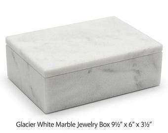 Op de afbeelding: Een rechthoekige sieradendoos van wit marmer met grijze aders. De doos heeft een afneembaar deksel en is gelabeld als Glacier White Marble Jewelry Box met afmetingen van 24,13 cm bij 15,24 cm bij 8,89 cm op het vooroppervlak.