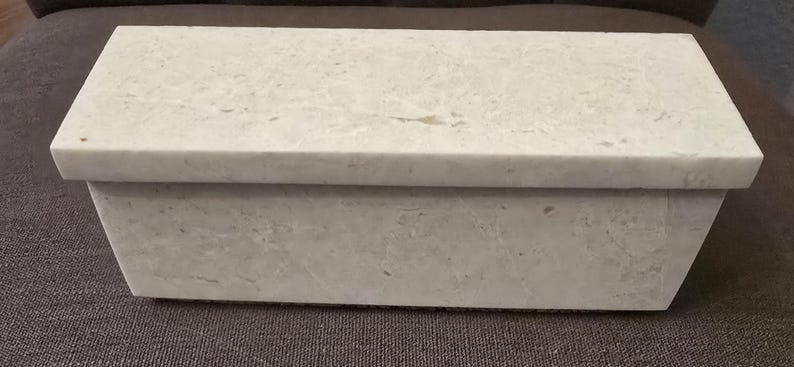 Puede incluir: Una caja rectangular blanca con una superficie texturizada. La caja est&aacute; hecha de un material que se asemeja al m&aacute;rmol.