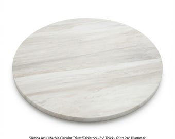 Puede incluir: Un salvamanteles o tablero de mesa circular de mármol Sienna Azul con una superficie lisa y pulida con vetas de color gris claro y blanco. El texto indica un grosor de 1,27 cm y diámetros que van de 15,24 a 60,96 cm.
