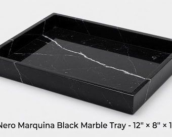 May include: A rectangular Nero Marquina black marble tray with white veining. The tray features raised edges and measures 12 inches by 8 inches by 1 inch as indicated by the text Nero Marquina Black Marble Tray - 12" x 8" x 1".