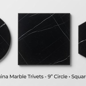 May include: Three Nero Marquina marble trivets in circle, square, and hexagon shapes, each featuring a black surface with white veining. The text below reads: Nero Marquina Marble Trivets - 9" Circle • Square • Hexagon.