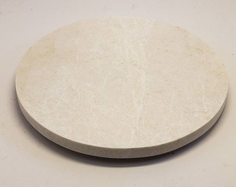 May include: A round, white marble serving tray with a smooth, polished surface.