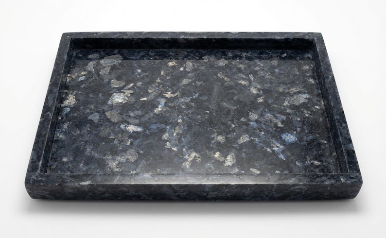 May include: A rectangular tray crafted from dark blue and black stone with a polished finish. The surface features a natural, mottled pattern of deep blue, charcoal, and silver-toned mineral inclusions throughout the entire structure.