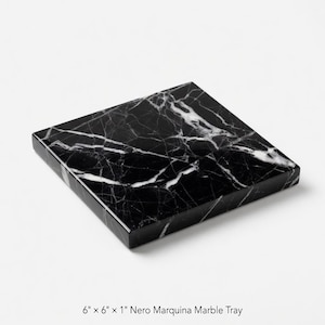 May include: Square Nero Marquina marble tray, 6 inches by 6 inches by 1 inch. The tray is black with white veining. The text at the bottom of the image reads "6" x 6" x 1" Nero Marquina Marble Tray."