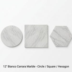 Könnte beinhalten: Drei 30,48 cm große Bianco Carrara Marmorstücke in Kreis-, Quadrat- und Sechseckform. Jedes Stück hat eine weiße Basis mit grauer Maserung. Der Text 12" Bianco Carrara Marble - Circle / Square / Hexagon steht unten auf dem Bild.