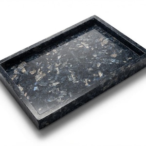 May include: A rectangular tray crafted from dark blue and black stone with a polished finish. The surface features a natural, mottled pattern with iridescent silver and light blue flecks embedded throughout the deep, dark base material.