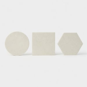 May include: Three vanilla-colored marble trivets in different shapes: a circle, a square, and a hexagon. The trivets are approximately 6 inches in diameter or width. The trivets have a brushed finish and are arranged against a white background.