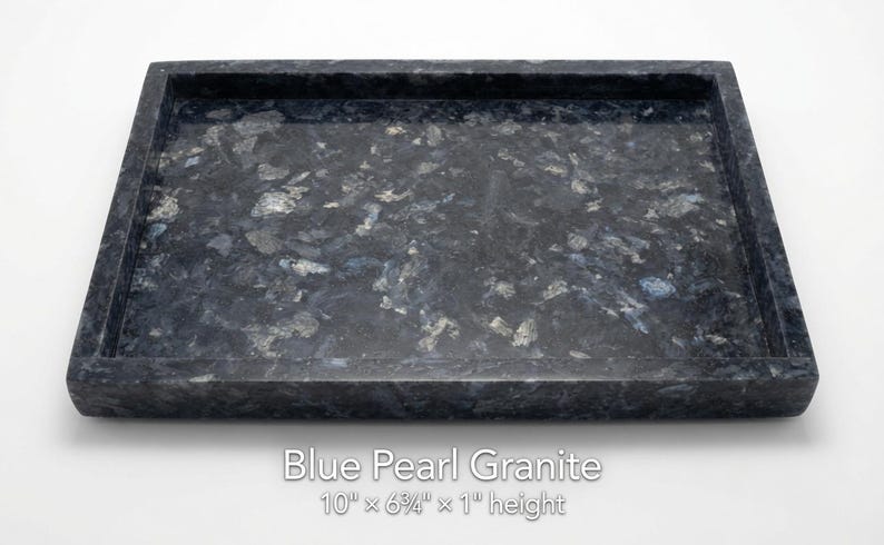 May include: A rectangular Blue Pearl granite tray with a polished surface featuring dark blue, black, and shimmering silver mineral flecks. The tray measures 10 inches by 6.25 inches by 1 inch in height, as indicated by the text printed below it.