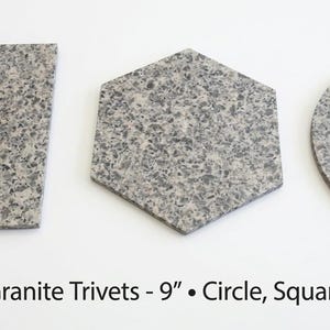 May include: Three Beige Mara granite trivets in square, hexagonal, and circular shapes. Each piece features a speckled grey and beige stone texture. The text below reads: Beige Mara Granite Trivets - 9" • Circle, Square & Hexagon.