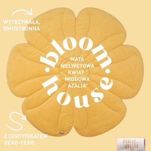 May include: A yellow flower-shaped play mat with the text "bloom.house" in a circle. The mat is made of velvet and has the text "MATA WELWETOWA KWIAT "MIODOWA AZALIA" in a smaller circle. The mat is labelled "WYTRZYMAŁA, DWUSTRONNA" and "Z CERTYFIKATEM Oeko-Tex&reg;".
