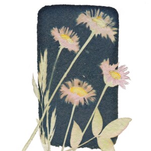 May include: A cyan blue background with pressed flowers in shades of pink and yellow. The flowers are arranged in a bouquet-like shape.