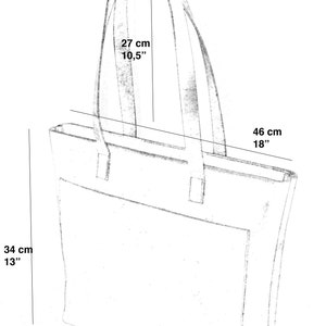 May include: A black and white sketch of a tote bag with measurements in inches and centimeters. The bag has a top handle and a zipper closure.
