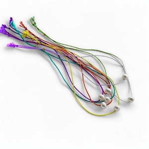 May include: A collection of colorful string necklaces with pearl accents. The necklaces feature various colors, including purple, green, yellow, and red. Some necklaces have a silver chain with pearls.