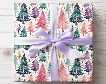 May include: A wrapped gift with a watercolor Christmas tree pattern. The gift is wrapped in white paper with colorful trees in shades of pink, green, and purple. A lavender satin ribbon is tied in a bow around the gift.